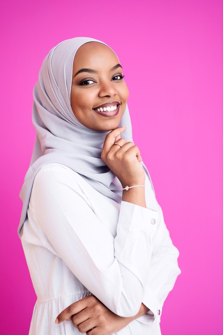 portrait de jeune beauté afro musulmane moderne portant des vêtements islamiques traditionnels sur fond rose en plastique