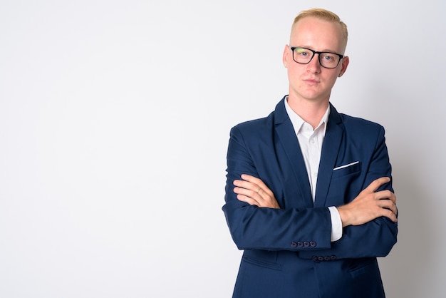 Portrait de jeune bel homme d'affaires aux cheveux blonds courts en costume et lunettes sur blanc