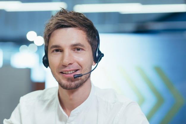 Portrait jeune bel homme au casque donne une conférence en ligne regarde l'appareil photo explique sourires dit conseille