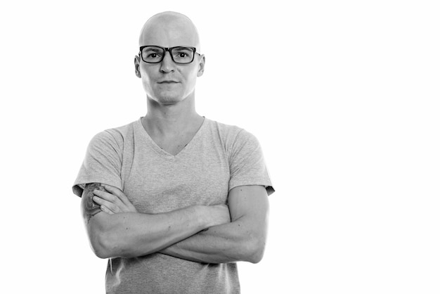 Portrait de jeune bel homme chauve avec des lunettes isolé sur blanc en noir et blanc
