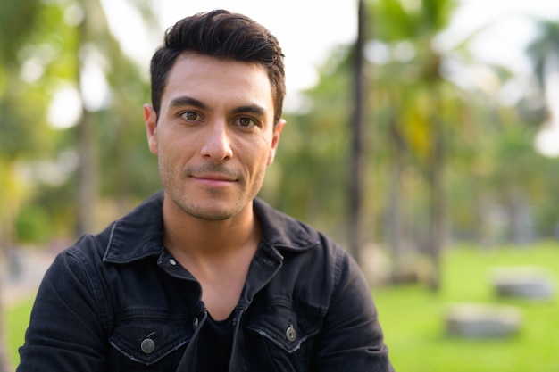 Photo portrait de jeune bel homme hispanique dans le parc à l'extérieur