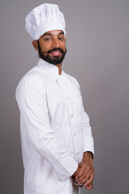 Portrait de jeune bel homme indien chef souriant