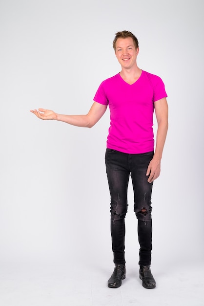 Photo portrait de jeune bel homme vêtu d'une chemise violette contre le mur blanc