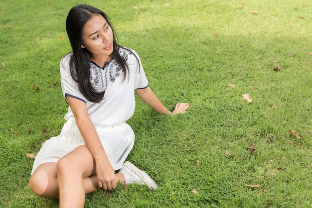 Portrait de jeune belle adolescente asiatique se détendre dans le parc en plein air