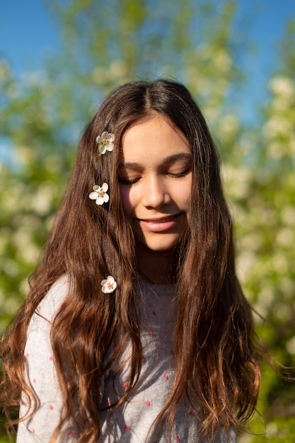 Photo portrait d'une jeune belle adolescente dans un jardin fleuri de printemps vert.