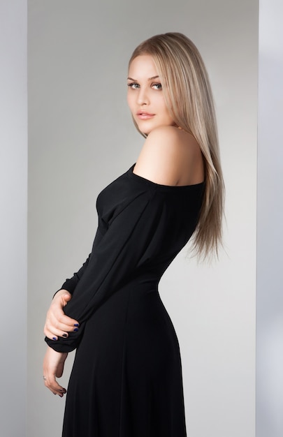 Portrait de jeune belle blonde caucasienne en robe magnifique sur fond blanc