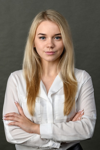 Photo portrait de jeune belle blonde femme d'affaires souriant sur fond gris.