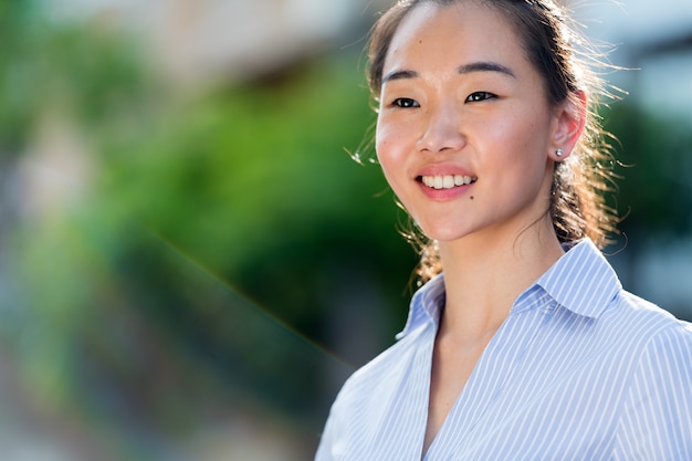 Portrait de jeune belle femme d'affaires asiatique dans les rues à l'extérieur