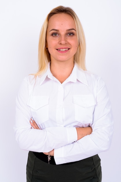 Portrait de jeune belle femme d'affaires aux cheveux blonds contre un mur blanc