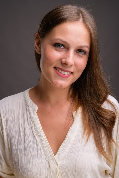 Photo portrait de jeune belle femme d'affaires contre le mur gris