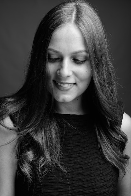 Portrait de jeune belle femme d'affaires sur gris en noir et blanc