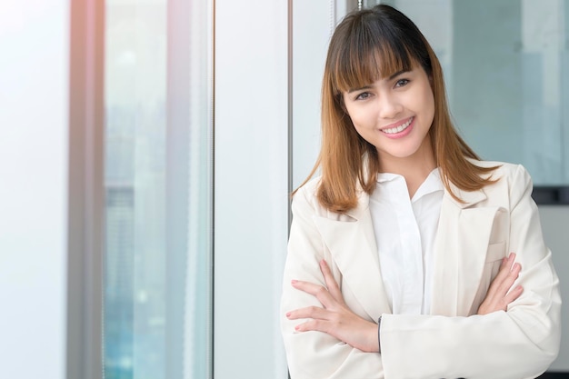 Portrait de jeune belle femme d'affaires souriant dans un bureau moderne