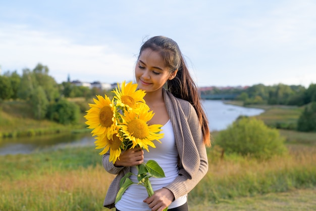 Portrait de jeune belle femme asiatique contre vue relaxante sur la rivière et champ vert luxuriant