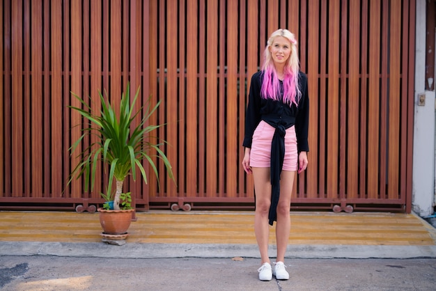 Portrait de jeune belle femme blonde à la découverte des rues de la ville à l'extérieur