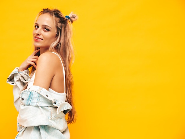 Portrait de jeune belle femme blonde souriante dans des vêtements d'été à la mode Sexy femme insouciante posant près d'un mur jaune en studio Modèle positif s'amusant à l'intérieur Enthousiaste et heureux