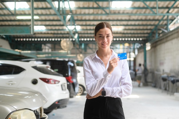 Portrait de jeune belle femme caucasienne souriante dans un atelier de réparation automobile