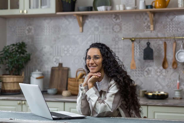 Portrait de jeune belle femme hispanique à la maison pigiste travaillant à distance à l'aide d'un ordinateur portable