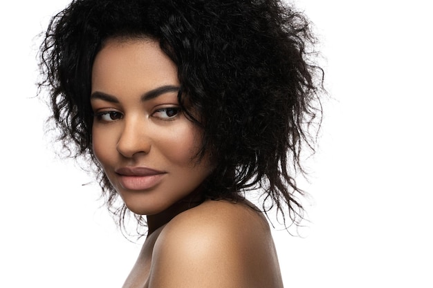 Portrait de jeune belle femme noire à la peau lisse sur fond blanc