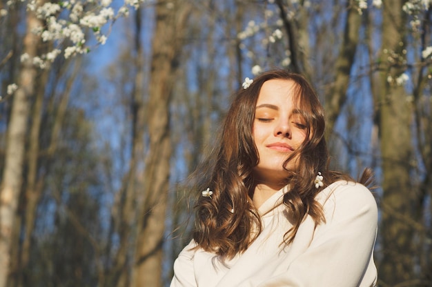 Portrait de jeune belle femme parmi les arbres en fleurs concept de printemps mode et beauté