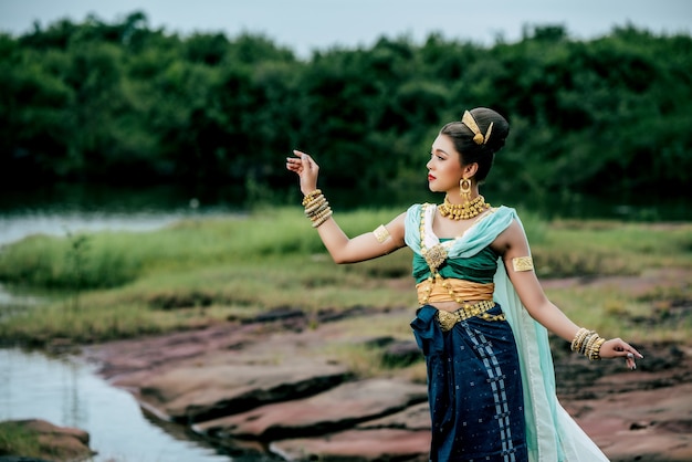 Portrait jeune belle femme portant en costume traditionnel avec ornement posant dans la nature en Thaïlande