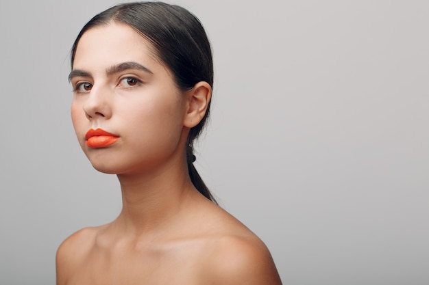 Portrait de jeune belle femme positive avec maquillage nude.