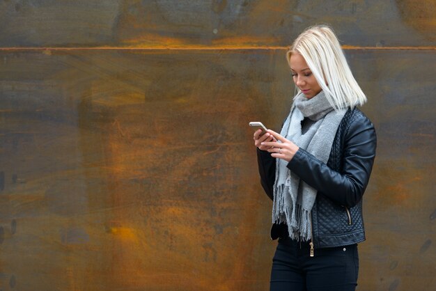 Portrait de jeune belle femme scandinave blonde contre le vieux mur de métal rouillé à l'extérieur