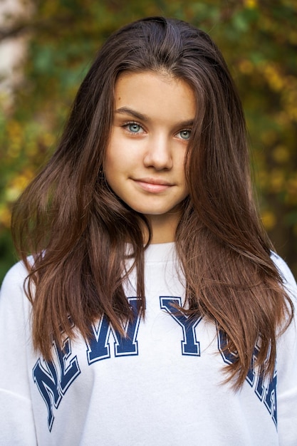 Photo portrait d'une jeune belle fille brune au parc d'automne en plein air