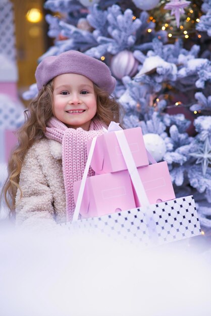 Portrait de jeune belle fille enfant enfant dans la décoration de Noël au jour de neige d'hiver près de