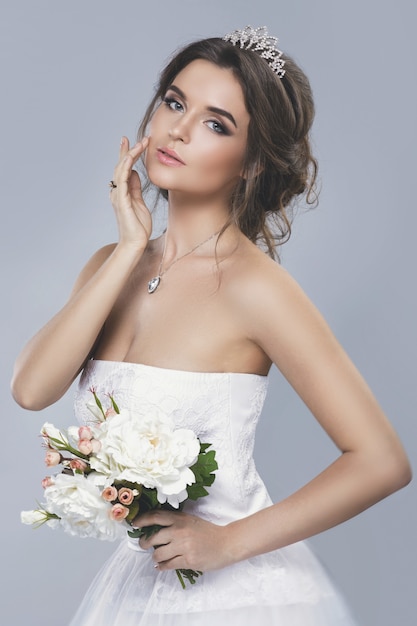 Portrait de jeune belle mariée avec bouquet de fleurs