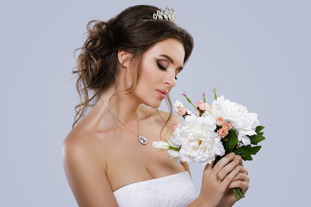 Portrait de jeune belle mariée avec bouquet de fleurs
