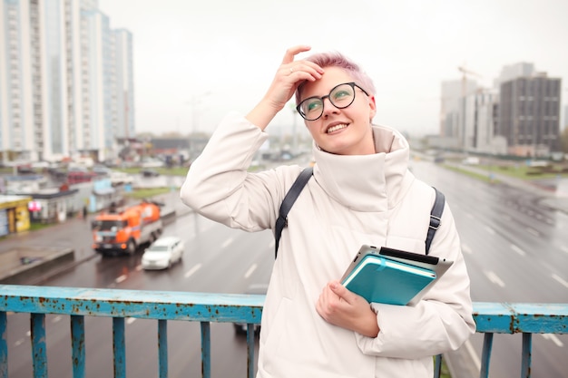 Portrait de jeune blogueur heureux avec ordinateur portable moderne et cahiers à l'extérieur