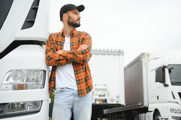 Portrait d'un jeune camionneur barbu debout à côté de son camion Service de transport Travail de chauffeur de camion