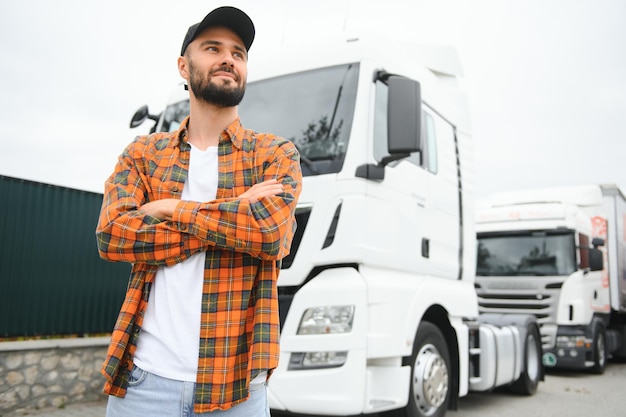 Photo portrait d'un jeune camionneur barbu debout à côté de son camion service de transport travail de chauffeur de camion