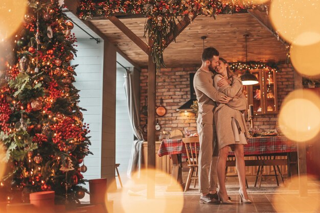 Photo portrait d'un jeune couple adorable s'étreignant à l'intérieur la veille du 25 décembre