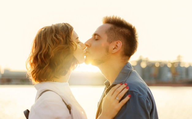 Portrait d'un jeune couple d'amoureux au coucher du soleil sur la mer