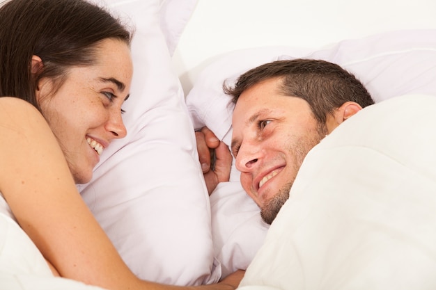 Portrait d'un jeune couple amoureux dans un lit