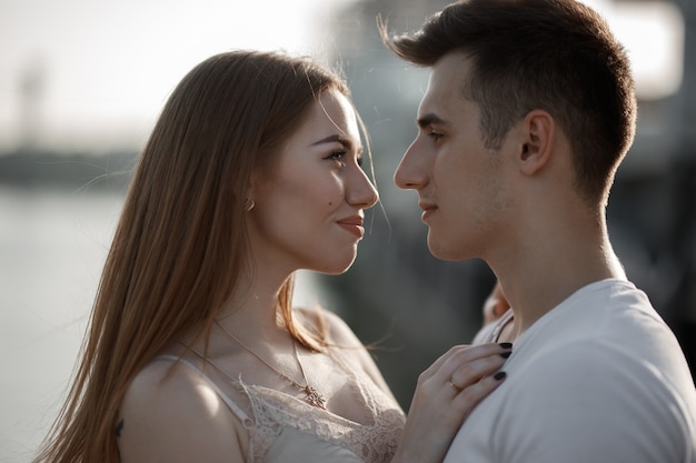 Portrait de jeune couple amoureux, profitant du coucher de soleil en ville.