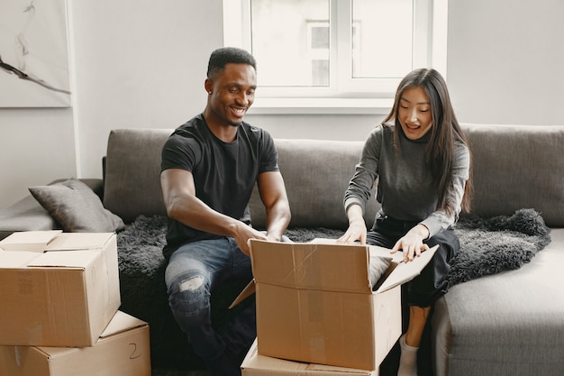 Portrait de jeune couple avec des boîtes en carton dans une nouvelle maison, concept de déménagement.