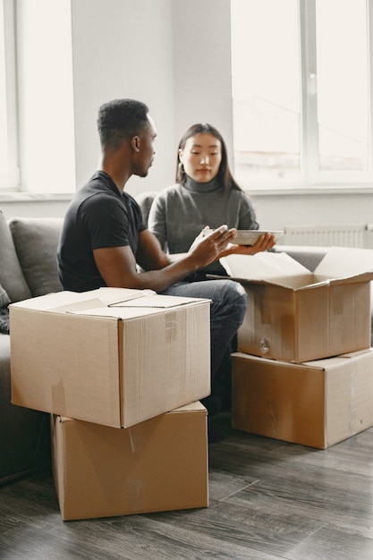 Portrait de jeune couple avec des boîtes en carton dans une nouvelle maison, concept de déménagement.