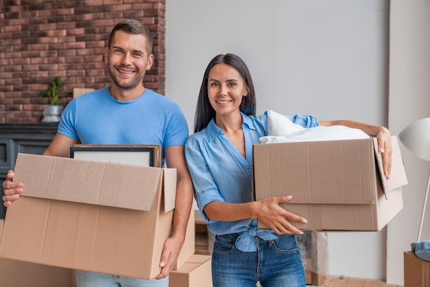 Portrait de jeune couple caucasien se déplaçant dans une nouvelle maison