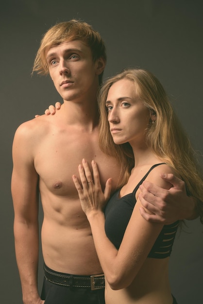 Photo portrait d'un jeune couple debout sur un fond noir