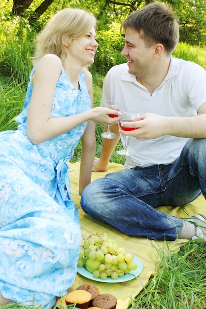 Portrait d'un jeune couple à l'extérieur avec des verres de vin