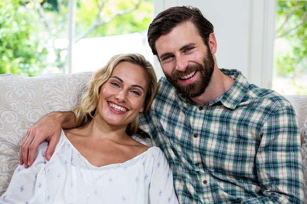 Portrait de jeune couple gai sur canapé