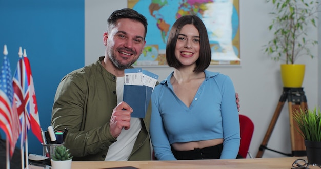 Portrait d'un jeune couple heureux dans une agence de voyage, ils obtiennent des billets d'avion pour un voyage d'été Concept de voyage