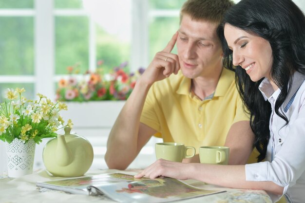 Portrait d'un jeune couple heureux lisant un livre intéressant