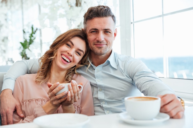 Portrait d'un jeune couple joyeux, boire du café