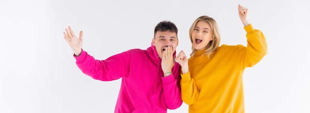 Portrait d'un jeune couple joyeux portant des sweats à capuche debout isolé sur fond blanc ok gest