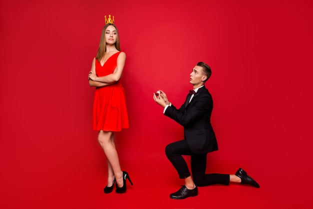 Portrait de jeune couple mignon sur fond rouge