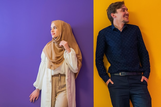 Portrait de jeune couple musulman femme en robe à la mode avec hijab isolé sur fond coloré représentant la mode moderne de l'islam et le concept de ramadan kareem.