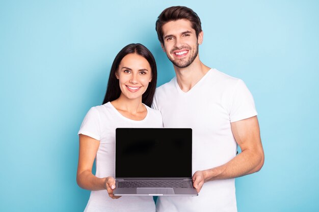 Portrait de jeune couple posant sur un mur de couleur bleue